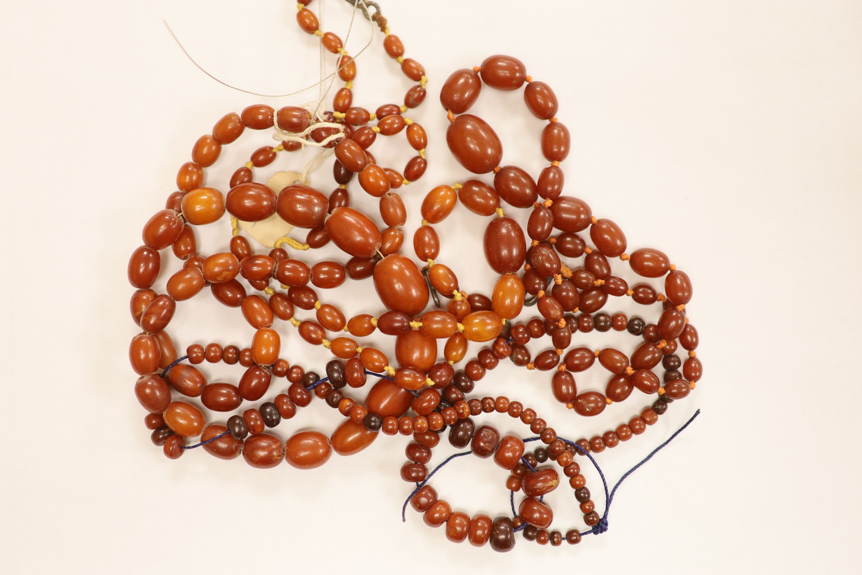 Nine assorted single strand amber bead necklaces, longest approximately 46cm, gross weight 173 grams and one simulated amber bead necklace.
